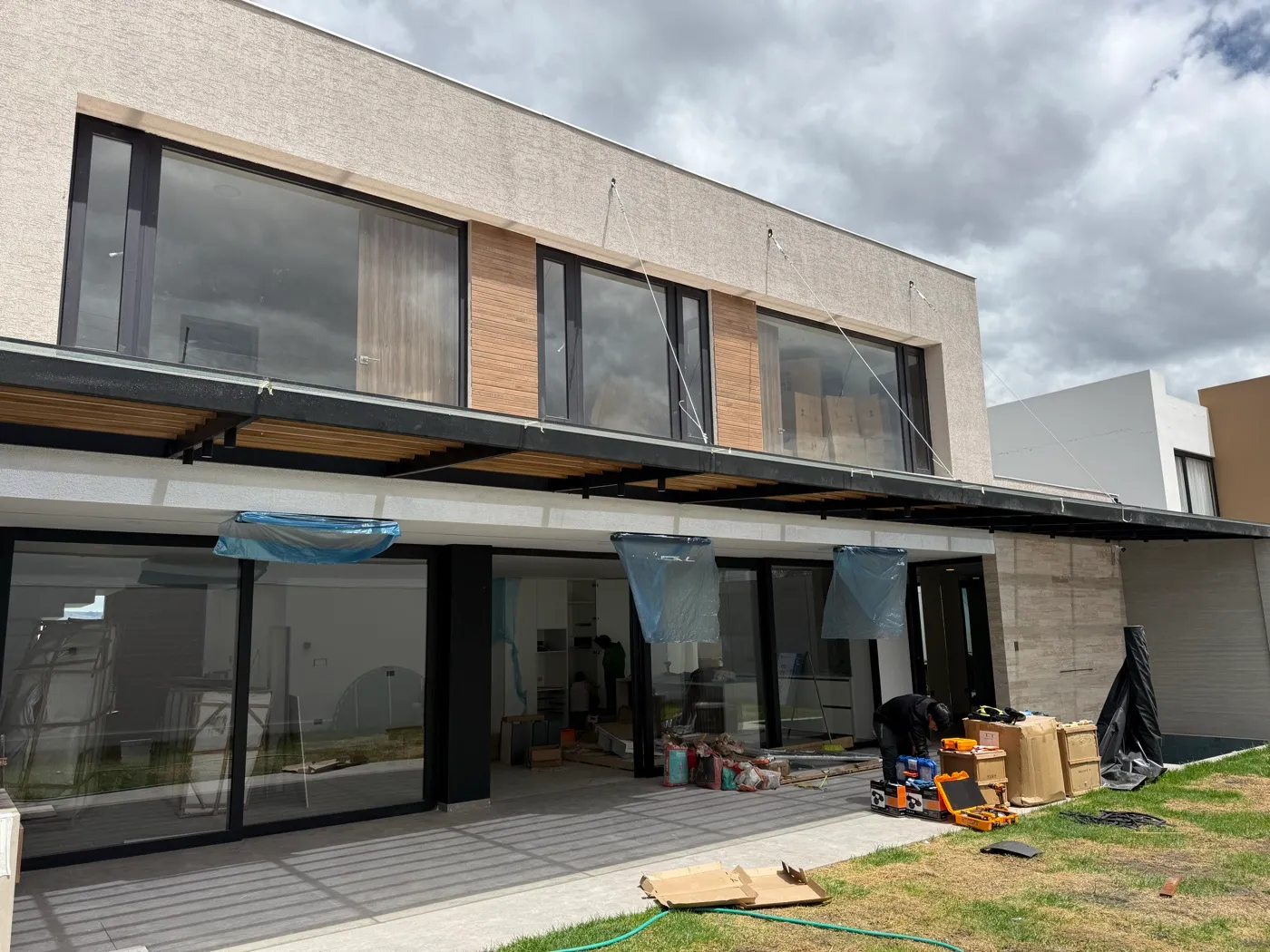 Casa moderna de dos pisos con fachada de vidrio y aluminio construida por Construvid