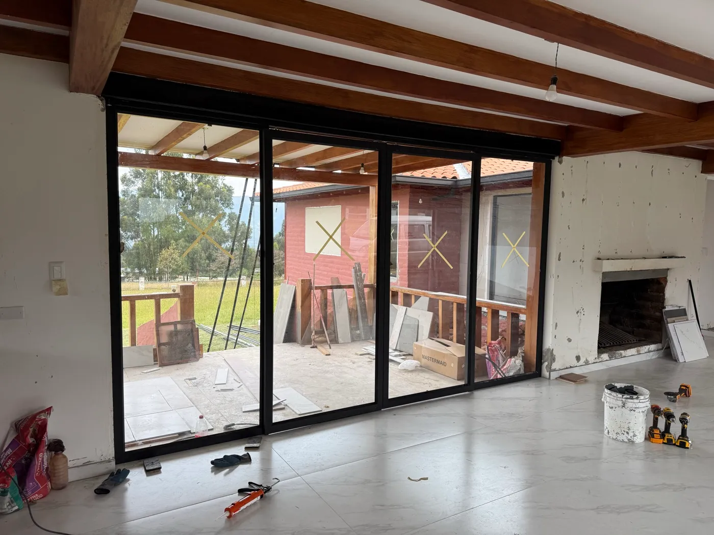 Ambiente con vigas de madera y puertas de vidrio hacia el exterior