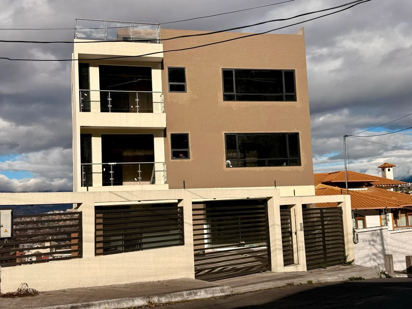 Edificio residencial de tres plantas con balcones y ventanería moderna