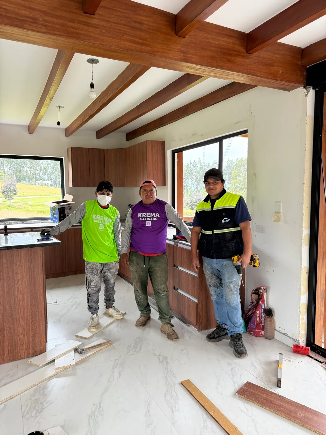 Miembros del equipo de Construvid Ec durante la instalación de acabados en una cocina