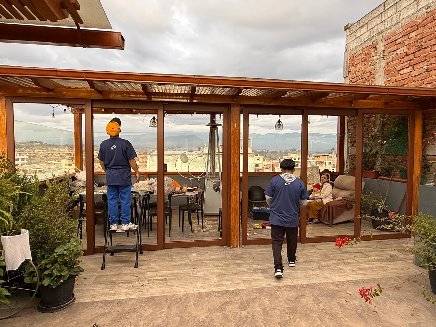 La terraza con pérgola en uso, con mesa y plantas