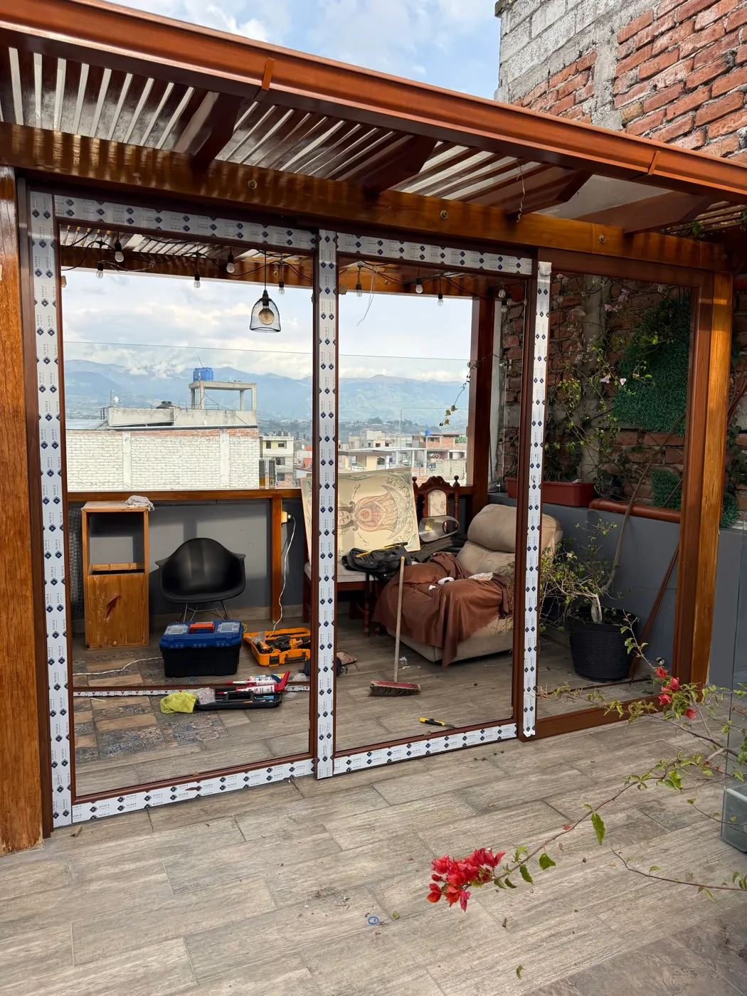 Terraza con pérgola de madera y cerramiento de vidrio instalado por Construvid