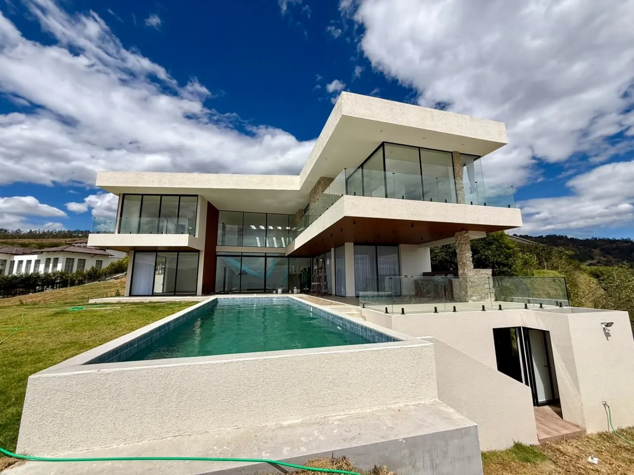Vivienda contemporánea con piscina desbordante construida por Construvid Ec en Tungurahua